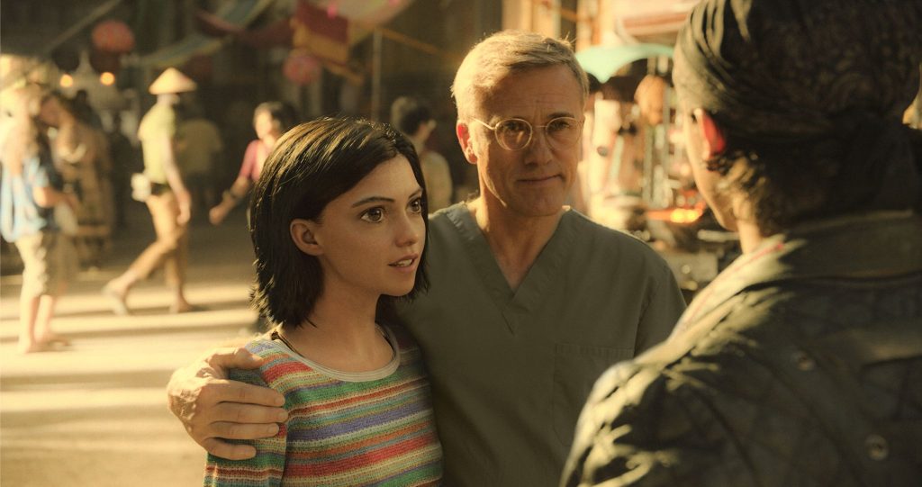 Movies like Ready Player One: Alita: Battle Angel (2019). Dr Dyson and Alita walk through the market in Iron City.
